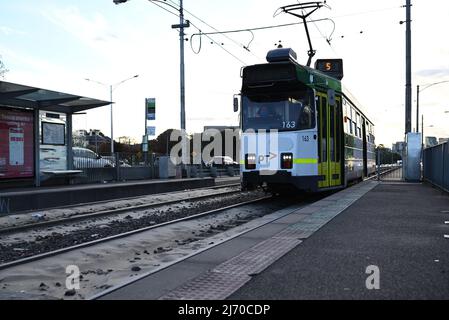 East bound Z-Class tram with masked driver, running on Route 5, as it pulls into the platform at the Chapel St stop on Dandenong Rd Stock Photo