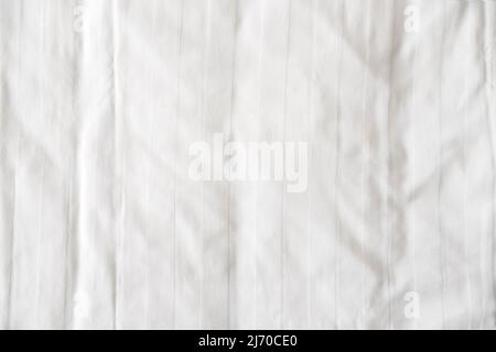 White bed linen, sheet as texture or background, crumpled blank bedclothes top view Stock Photo