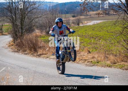 Prague, Czech Republic - March 13, 2022: Unknown rider of motocross on rural road near Prague Stock Photo
