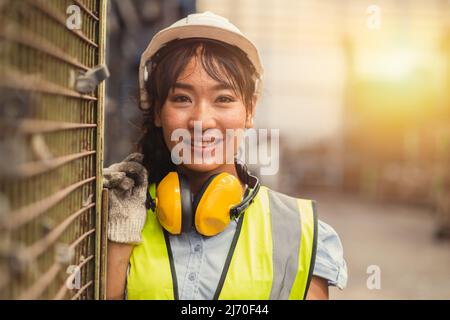 Engineer woman worker, Asian working women happy smiling in hevy industry machinery factory. Stock Photo