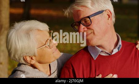 Closeup outdoor portrait of two elderly retired caucasian people - man and woman - looking each other in the eye. Happy long marriage. High quality photo Stock Photo