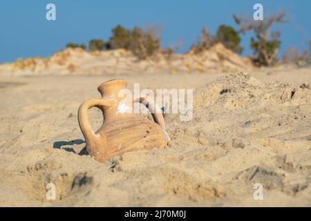 View to greek amphora on a sandy beach. Greece Stock Photo
