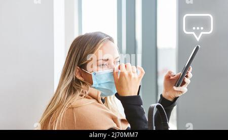 Woman with mask thinking or waiting on her smartphone with messaging symbol Stock Photo