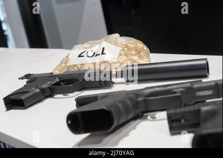 05 May 2022, Hessen, Frankfurt/Main: Pistols and ammunition seized by customs lie on a table during the annual press conference of the Frankfurt Main Customs Office at Frankfurt Airport. Photo: Sebastian Gollnow/dpa Stock Photo