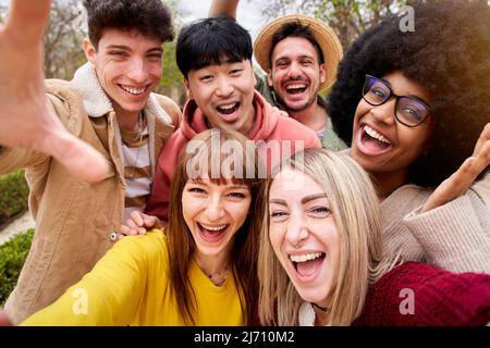 Big group of cheerful young friends taking selfie portrait. Happy people looking at the camera smiling. Concept of community, youth lifestyle and Stock Photo