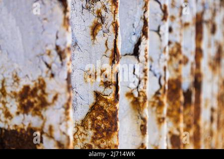 Metal bridge railing with corrosion, rust, deep cracks, and paint flaking texture Stock Photo