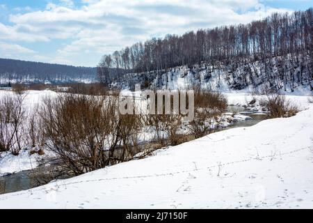View of the Bolshaya Podikova River in spring with snow-covered banks, Kemerovo region-Kuzbass Stock Photo