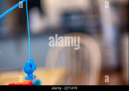 Children's game of using a miniature pole and line lowered into open  plastic fish to catch them as the pond spins Stock Photo - Alamy