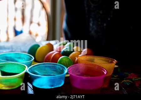 Plastic cups for dying Easter eggs with finish carton in the background. Stock Photo