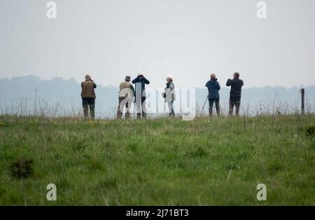a group of bird watchers (twitchers) gather in search of a reported crane pair sighting on Salisbury Plain, Wiltshire Stock Photo