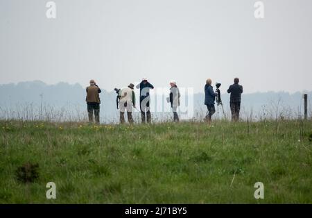 a group of bird watchers (twitchers) gather in search of a reported crane pair sighting on Salisbury Plain, Wiltshire Stock Photo
