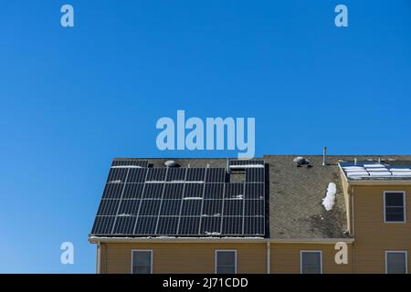 Man installing photovoltaic solar panels alternative energy on roof Stock Photo