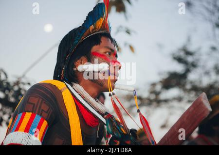 Indigenous man from a Brazilian Amazon tribe wearing feather headdress known as cocar and tribal body art. Xingu River, Amazon, Brazil. 2009. Stock Photo