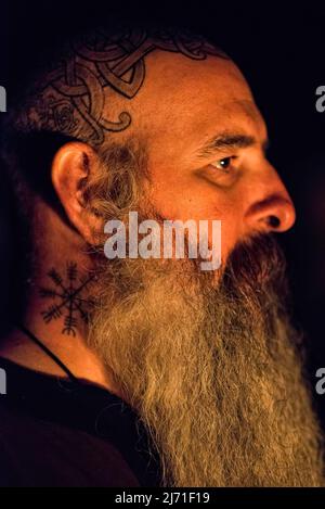 A member of the pagan community shows off his beard and tattoos. The ...