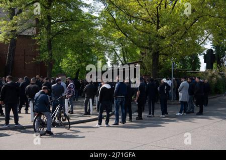 05 May 2022, Berlin: Mourners stand outside the New Twelve Apostles Churchyard in the Schöneberg district before the funeral of a 25-year-old member of an Arab clan. The man had been stabbed to death on Saturday (30.04.2022) at a funfair in Park Hasenheide during an argument. About 1000 men and a few women were mourners at the cemetery. Photo: Paul Zinken/dpa Stock Photo