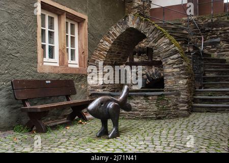 Statue in front of a well and a bench on cobblestone in Bacharach, Germany. Stock Photo