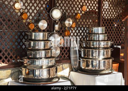 kitchen pans stand in a stack outside in the shade, a set of kitchen gray pans Stock Photo