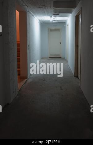 Corridor with storage room doors in apartment building basement. Stock Photo