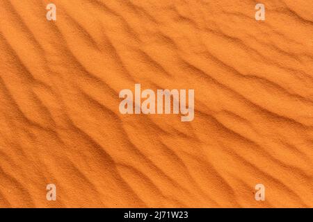 Background texture wallpaper - close-up detail of wind-blown ripples in the red sand of the Kalahari Desert, Namibia Stock Photo