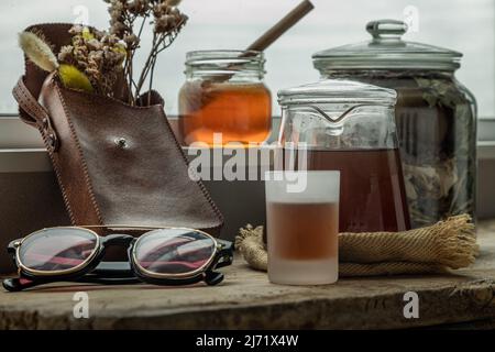 Refreshing with Chinese herbal tea (Jub Lieng) served with honey on old wooden table with city view. Herbal plant and healthy drinks concept, Selectiv Stock Photo