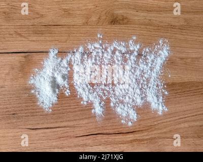 White flour on wooden table. View from above. Top view. Stock Photo