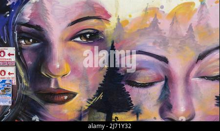 Mural depicting close-up faces of two girls on the wall of Colegio de Santo Domingo de Vistillas Garden. Realejo, Granada, Andalucia, Spain Stock Photo