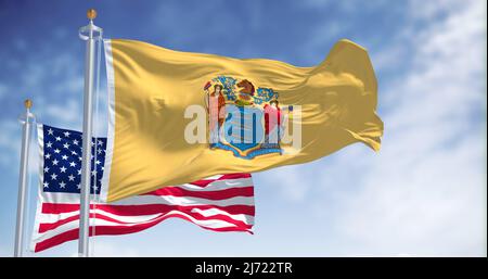 The New Jersey state flag waving along with the national flag of the United States of America. In the background there is a clear sky. New Jersey s a Stock Photo