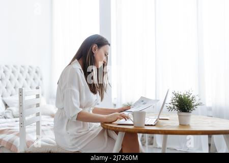 young woman analyzing financial documents in her home office. Stock Photo