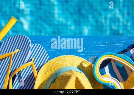 Beach flip-flops and snorkel mask on blue wood against swimming pool background. Summer vacation and travel concept concept Stock Photo
