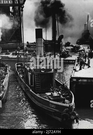 Tug Raised By Titan Crane - The tug EMU being raised by the Titan crane at the sugar refinery wharf at Glebe Island this morning. The EMU sank after a collision on January 10. (The smoke which appears to be coming from the EMU's funnel is in reality coming from a funnel on the Titan crane. February 18, 1949. (Photo by Ronald Leslie Stewart/Fairfax Media). Stock Photo