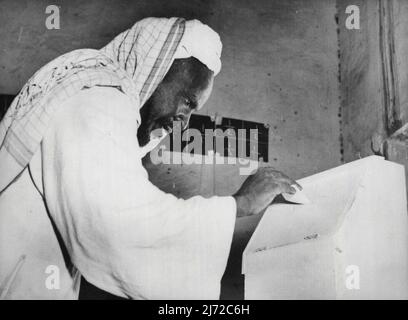 Sudan Elections - A cotton cultivator drops his ballot paper into a box during voting at Messelemiya. Polling in the direct constituencies for the Sudan Parliament, which began on November 15, is staggered over a period of ten days. Wad Madani, capital of the cotton province of Blue Nile, went to the polls on November 20, and Messelemiya, a village in the Gezira cotton area itself, polled on November 21. November 26, 1953. (Photo by Associated Press Photo). Stock Photo