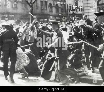 Police Charge Meeting -- Women fall to ground as baton-wielding police charge a protest meeting in front of the city hall in Johannesburg, South Africa. Melee ensued after police arrested E. S. Sachs, veteran labor organizer, who was addressing a meeting called to demonstrate against a Ministry of Justice order to Sachs to quit his post as general secretary of the Garment Workers Union. Although melee took place May 24, these pictures have just become available in the United States by mail from South Africa. June 26, 1952. (Photo by AP Wirephoto). Stock Photo