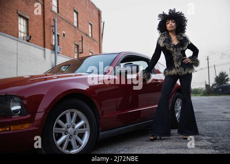 Full length tough portrait of a young African American woman with her car. Stock Photo