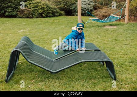 A little boy in sunglasses crawls on a park bench Stock Photo - Alamy