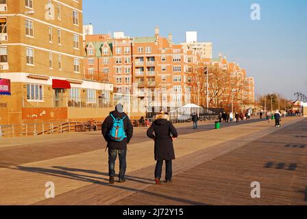 An adult couple walks along the boardwalk in the Brighton Beach neighborhood of Brooklyn on a winter's day Stock Photo
