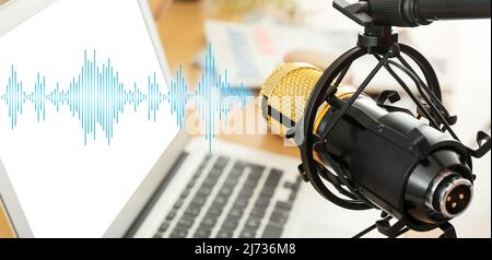 Professional microphone near workplace with laptop, closeup Stock Photo