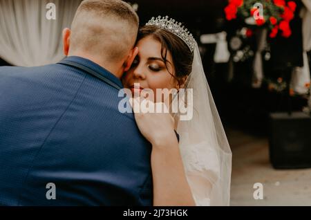 groom in suit and bride in dress in veil tiara dance together their first wedding dance. Slavic Ukrainian Russian traditions Stock Photo