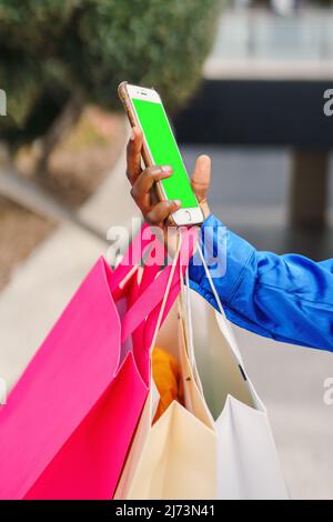 Crop black shopper using smartphone with green screen Stock Photo