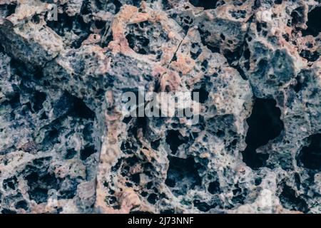 Macro close up rock crack stone solid foamy form raw porous lava volcanic frozen creates pumice ancient lunar style. Light black gray craters lunar Stock Photo