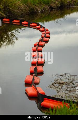 A containment boom is a temporary floating barrier used to contain an oil spill. Booms are used to reduce the possibility of polluting shorelines and Stock Photo