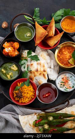 Indian Thali on dark background. Traditional food concept. Organic food concept. Dishes and appetisers of indeed cuisine. Top view, flat view, copy sp Stock Photo