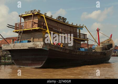 A wooden ship on Musi river in Palembang, South Sumatra, Indonesia. I-Tsing (Yijing), a 7th century Chinese monk who travelled the maritime silk road to reach India to learn Buddhism had reported that he took a Persian ship from Kwang-tung (Guangzhou, Guangdong) to get into Srivijaya capital, from where he took 'a king's ship' to reach to India. Stock Photo