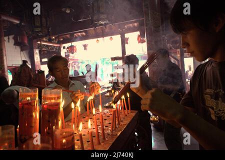 Devotees burning incense sticks at Chandra Nadi (Soei Goeat Kiong) temple in Palembang, South Sumatra, Indonesia. During its peak period, from 7th to early 11th century, Srivijaya had strong relationships with the strongest rulers in China, India, and Arab world—often through religious approaches. The diplomacy helped the thalassocracy to build its significance in sea trade. Stock Photo