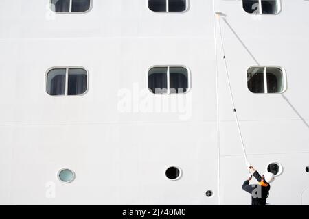 Rome, Italy - September 15: A worker is cleaning the white surface of a cruise ship before cruise start Stock Photo
