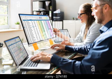 Analyst Employee Working On Spreadsheet Using Desktop Computer Stock Photo