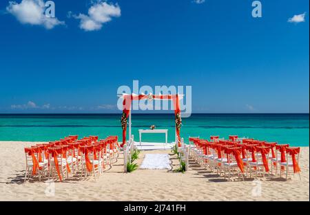 Romantic Wedding setting up with red decorations on the beach. Stock Photo