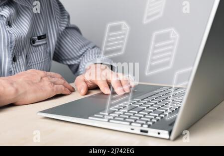 Businessman using laptop for electronic documents, letters sending and receiving. Man sitting at desk with computer. Online communication and paper flow concept. High quality photo Stock Photo