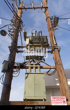 Outdated electricity supply, a mess of wires on wooden poles Stock Photo