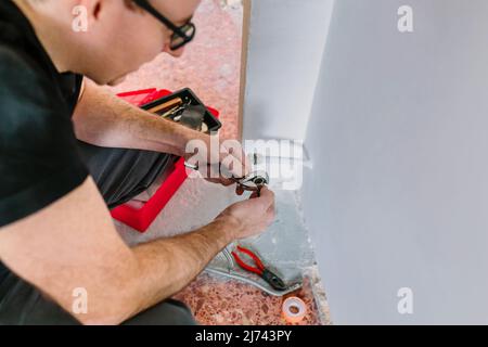 Plumber adjusting spanner to install heating Stock Photo