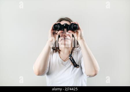 Woman with binocular. Businesswoman looking through binoculars. Stock Photo